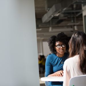 Foto van twee vrouwen die met elkaar praten. Dit is de omslagfoto op de pagina met tips hoe je een mondeling examen aan kan pakken.